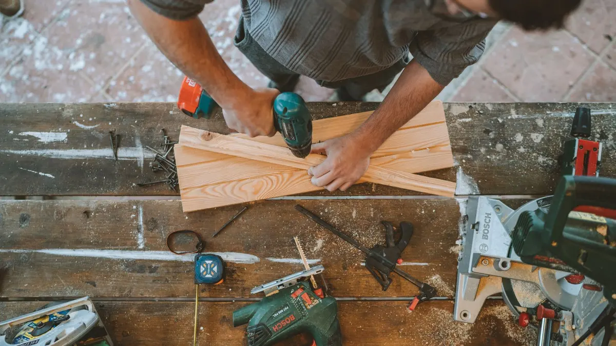 Étagère murale en bois chargée de livres, équerres métalliques fixées dans un mur blanc